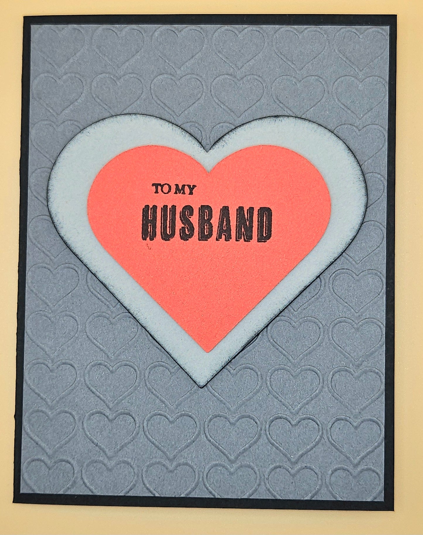 Card with a heart design and 'To my Husband' text on a textured background