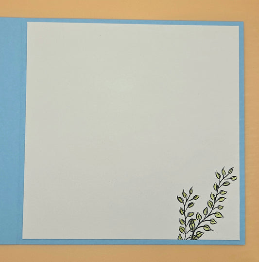 White card with blue border and green leaf design on a beige background