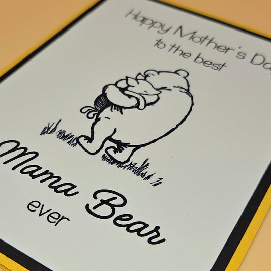 Card with illustration of a bear and text 'Happy Mother's Day to the best Mama Bear ever' on a yellow border.