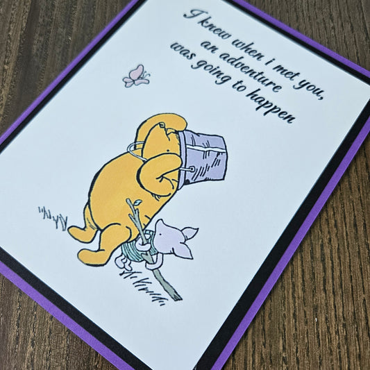 Cartoon character with a purple hat and a small animal on a card with text.