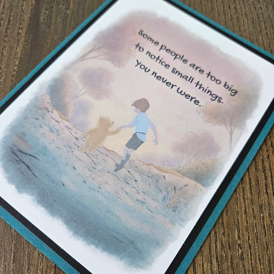 Card with illustration of person climbing a mountain and text on a wooden surface