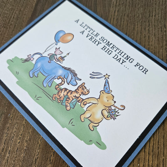 Greeting card with cartoon characters and text on a wooden surface