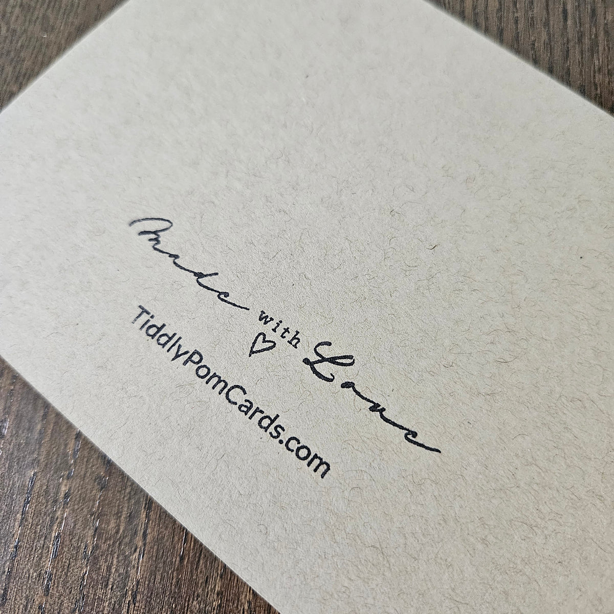 Card with 'Made with Love' text and website address on textured paper