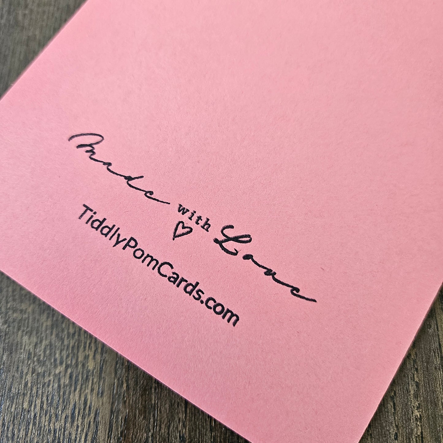 Pink card with 'Made with Love' and TiddlyPomCards.com text on a wooden surface