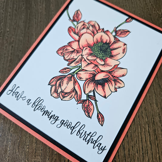 Greeting card with floral design and text on a wooden surface
