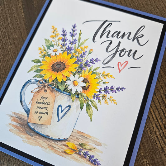 Close-up of the sunflower thank you card showing floral mug artwork and the tag reading Your kindness means so much.