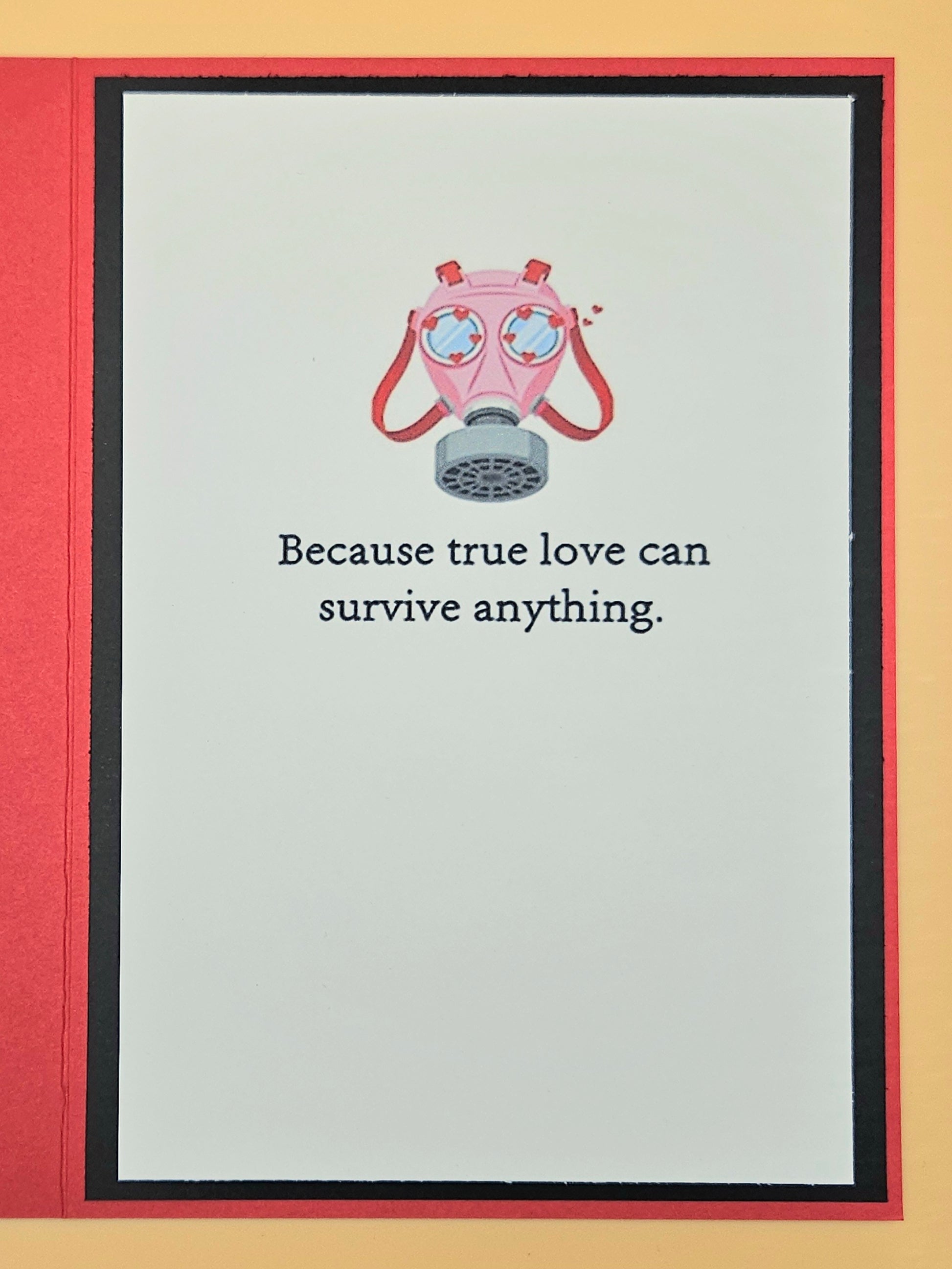 Pink gas mask on a card with text 'Because true love can survive anything.'