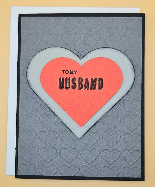 Card with a pink heart and 'To my Husband' text on a gray background with heart patterns