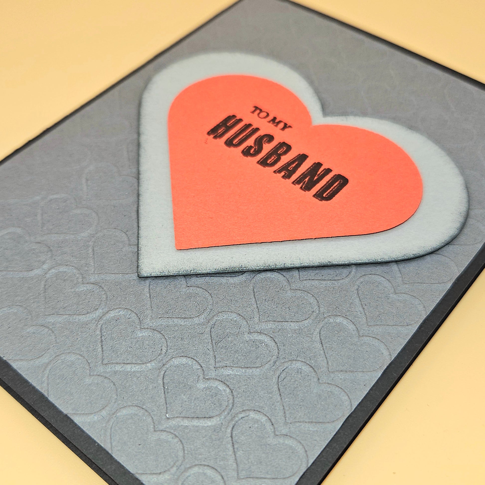 Heart-shaped card with 'To My Husband' text on a textured heart-patterned card