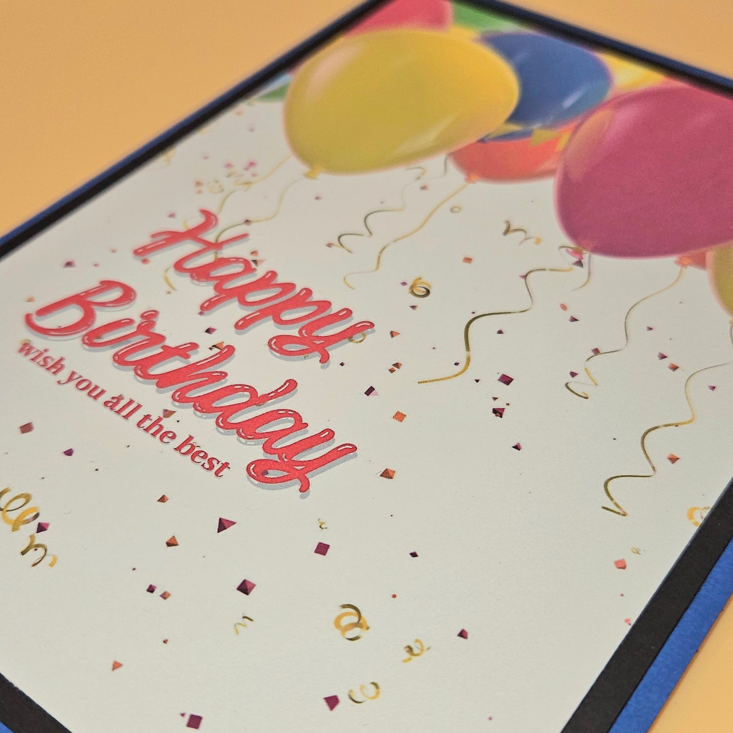 Birthday card with colorful balloons and confetti on a wooden surface