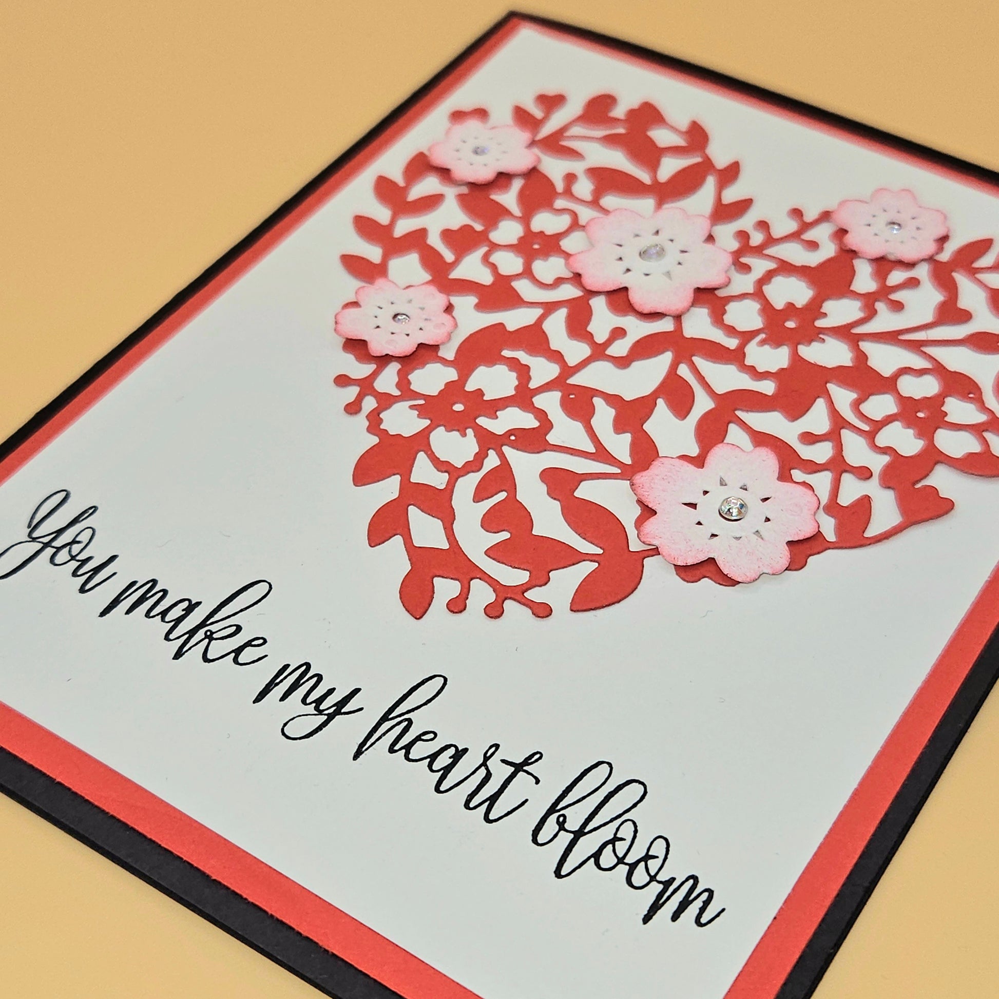 Card with floral design and text 'You make my heart bloom' on a beige background