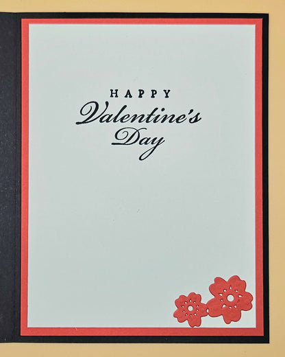 Valentine's Day card with 'Happy Valentine's Day' text and red flowers on a light blue background.