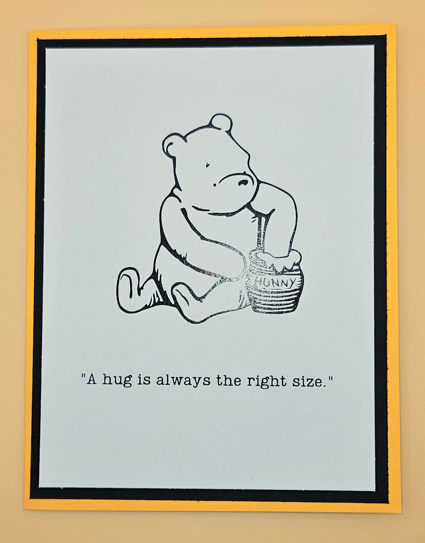 Illustration of a bear holding a honey pot with text on a light blue background, framed in yellow.