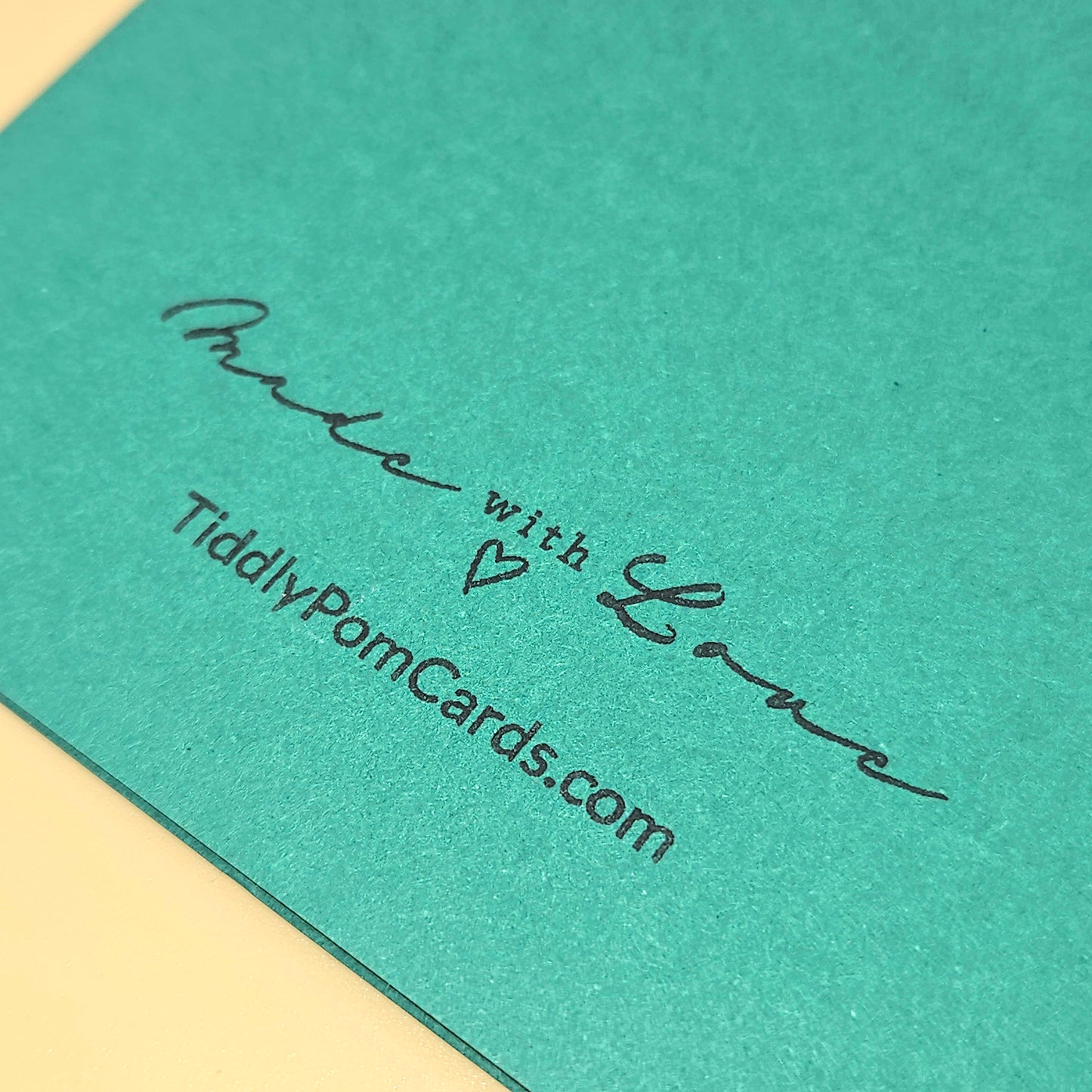 Teal card with 'Made with Love' text and website URL on a beige background