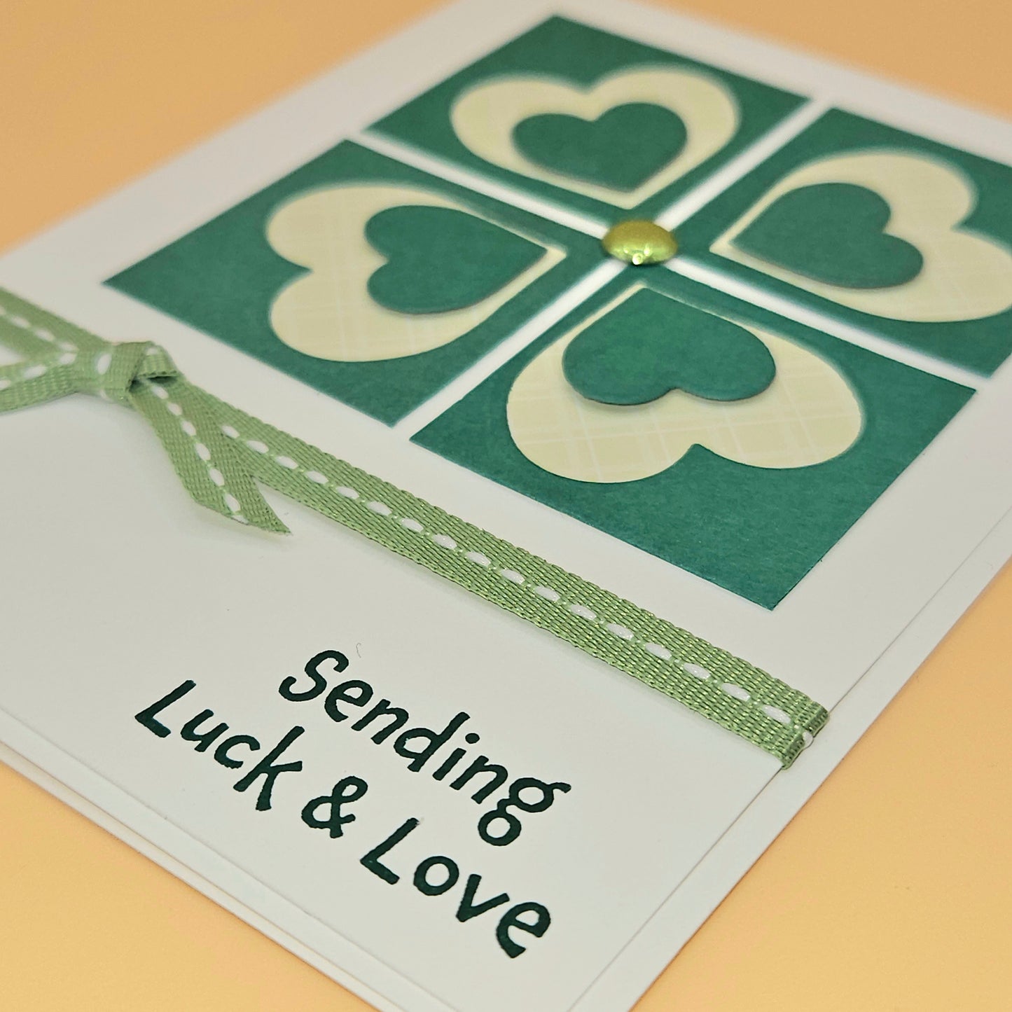Card with heart design and text 'Sending Luck & Love' on a beige background