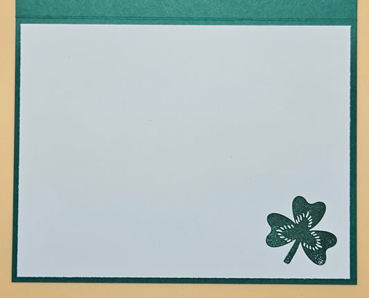 Four-leaf clover design on a white card with green border