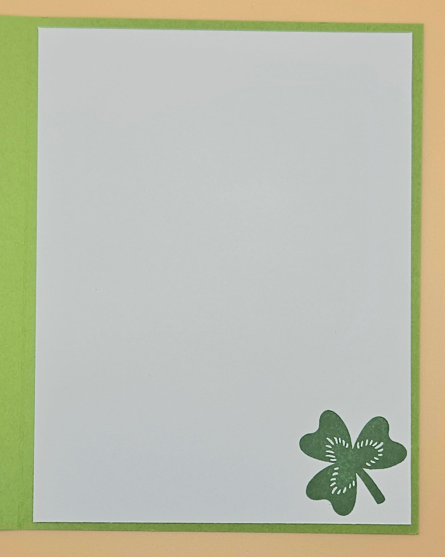 Card with a green four-leaf clover design on a light gray background