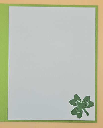 Card with a green four-leaf clover design on a light gray background