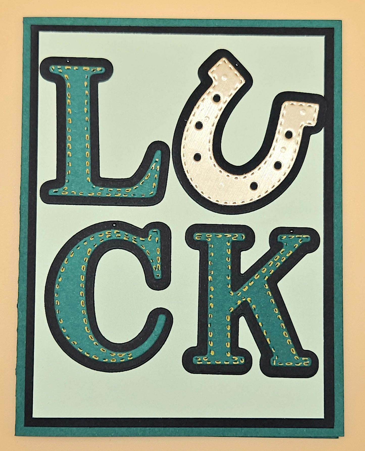 Decorative sign with the word 'LUCK' in stylized letters on a beige background