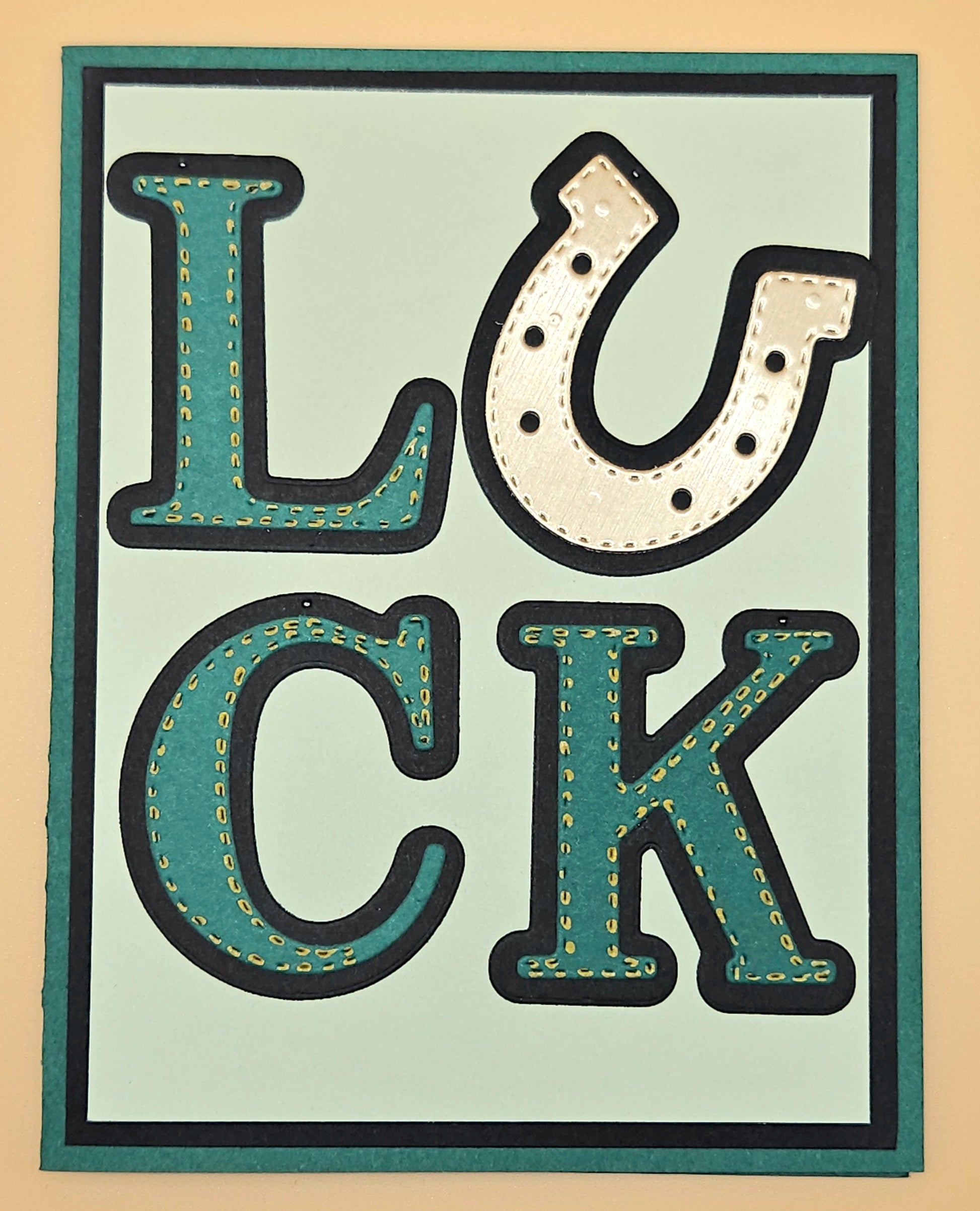 Decorative sign with the word 'LUCK' in stylized letters on a beige background