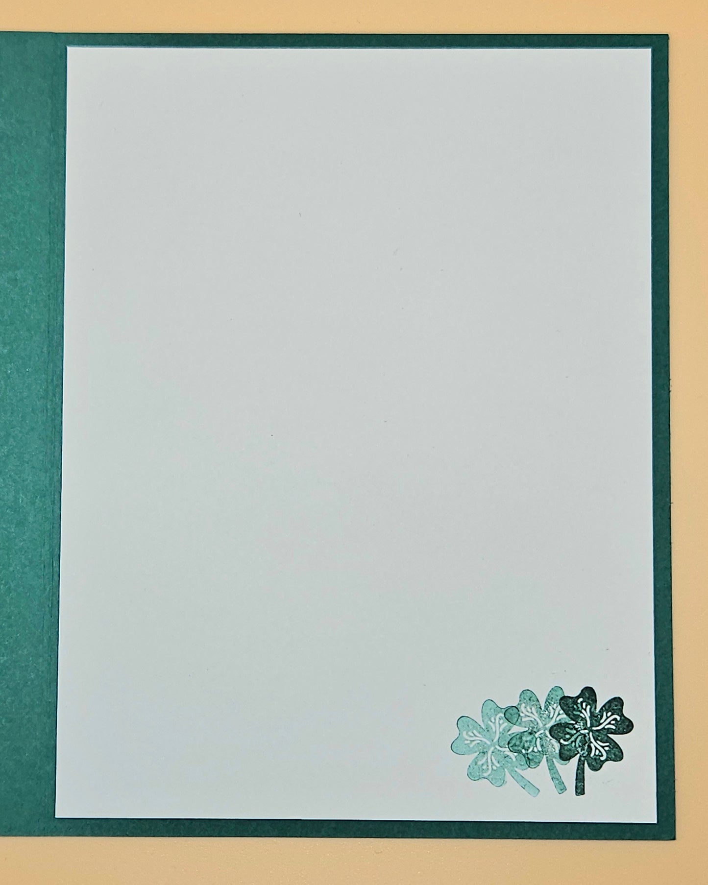 White card with green border and four-leaf clover design on a beige background