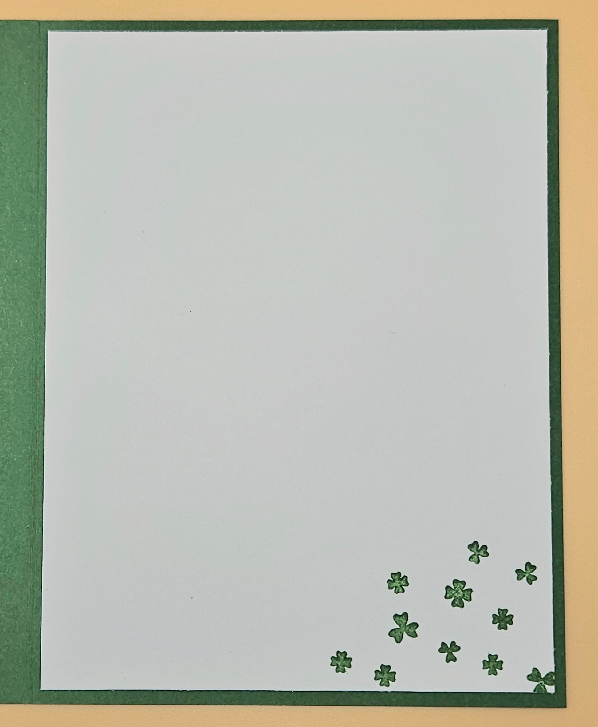 White card with green shamrock patterns on a gold and green border