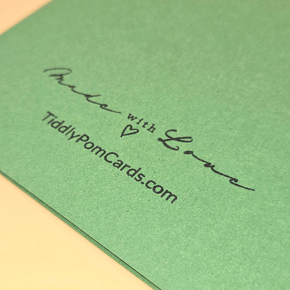 Green card with 'Made with Love' and 'TiddlyPomCards.com' text on a beige surface