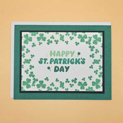 St. Patrick's Day card with green shamrocks and 'Happy St. Patrick's Day' text on a beige background