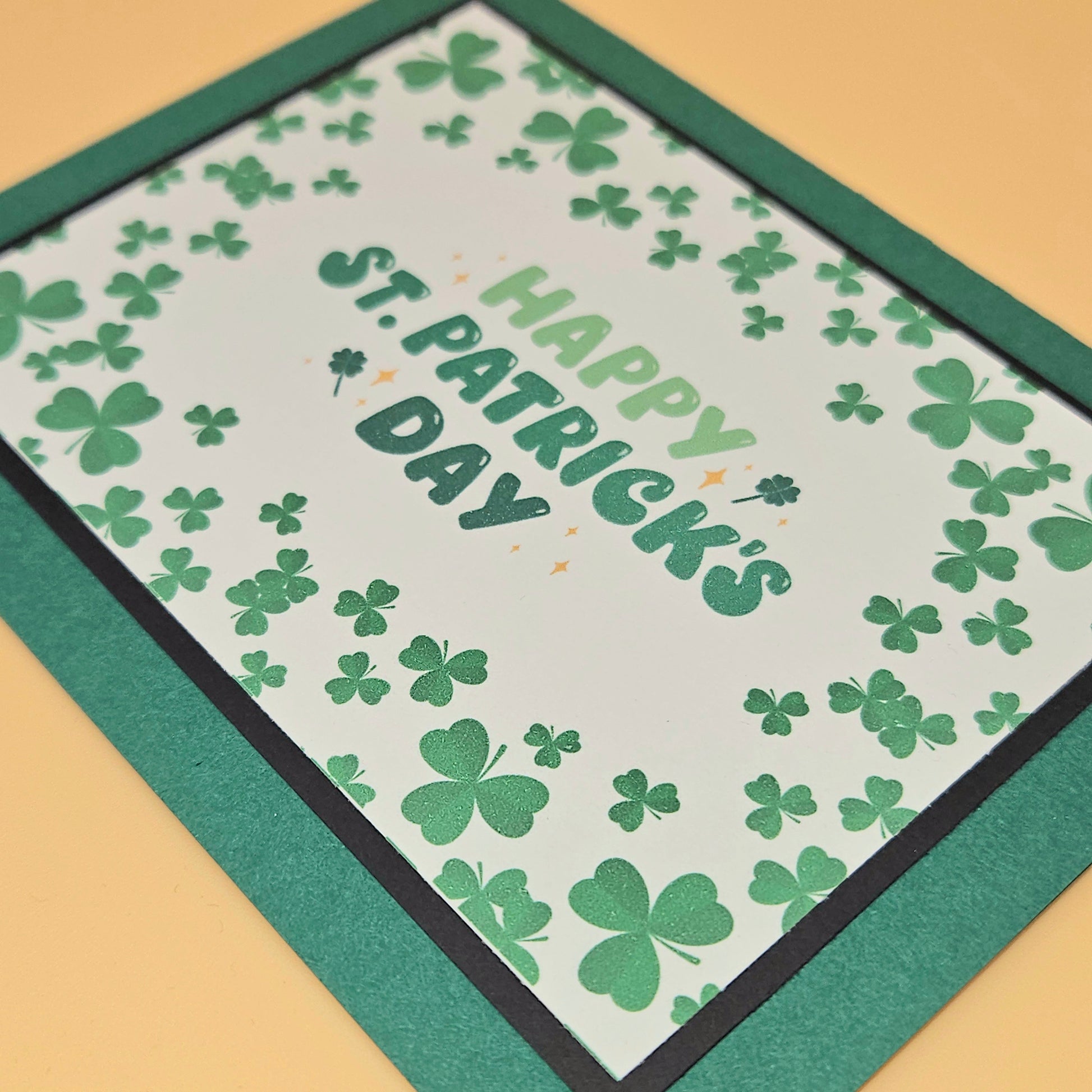 St. Patrick's Day card with green shamrocks and 'Happy St. Patrick's Day' text on a beige background.