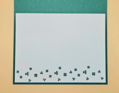 Green border with small clover patterns on a beige background