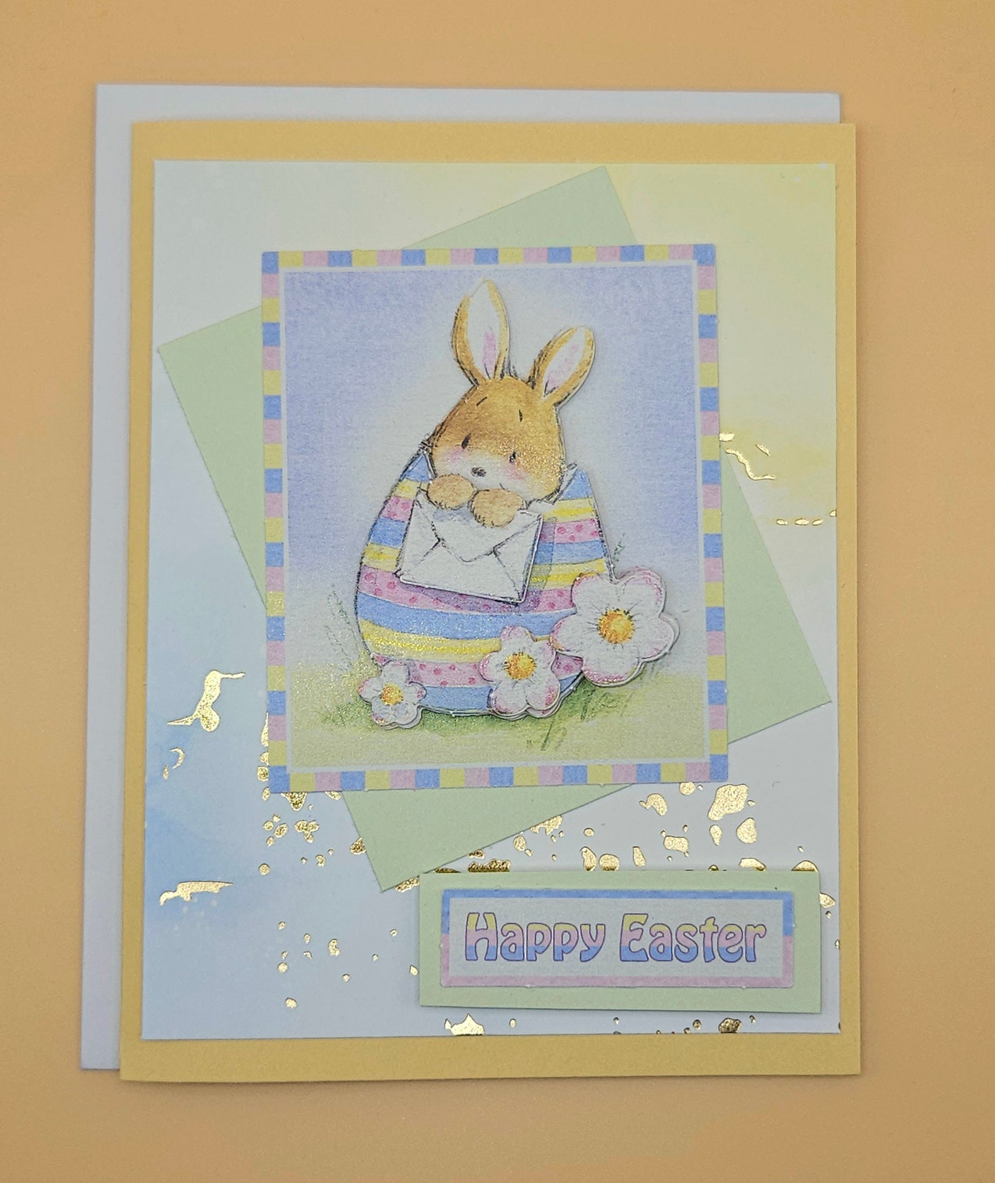 Easter card with a bunny holding a flower on a beige background