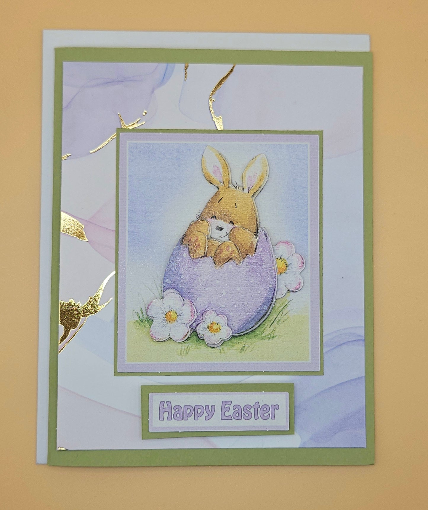 Easter card with a bunny in an egg and 'Happy Easter' text on a beige background