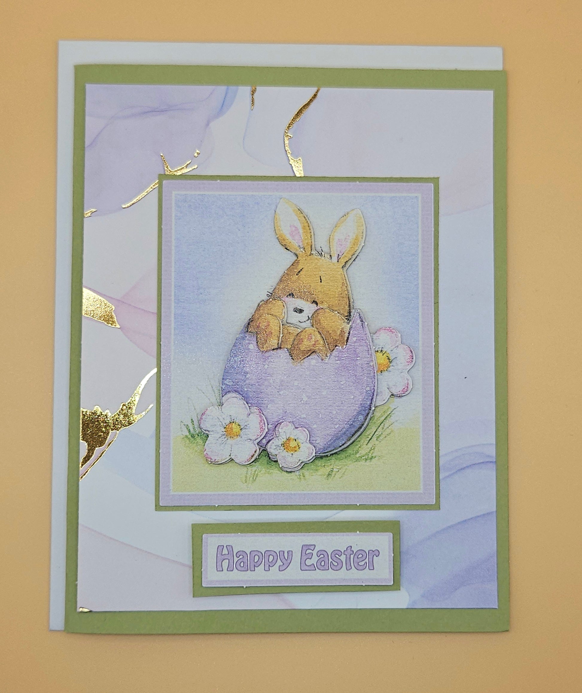 Easter card with a bunny in an egg and 'Happy Easter' text on a beige background
