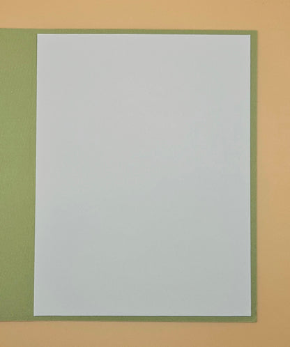 White sheet of paper with green border on a beige background
