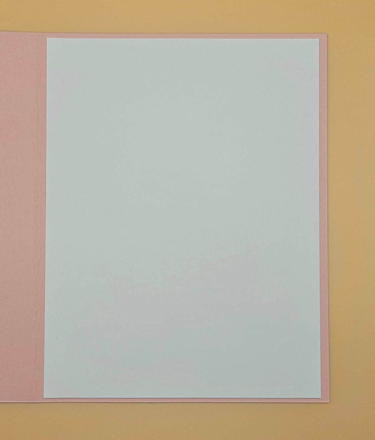 White sheet of paper with pink border on a yellow background