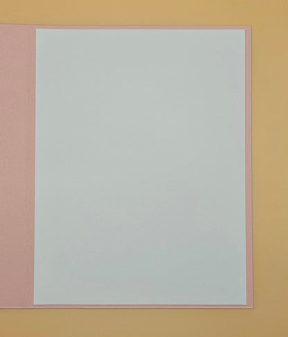 White sheet of paper with pink border on a yellow background