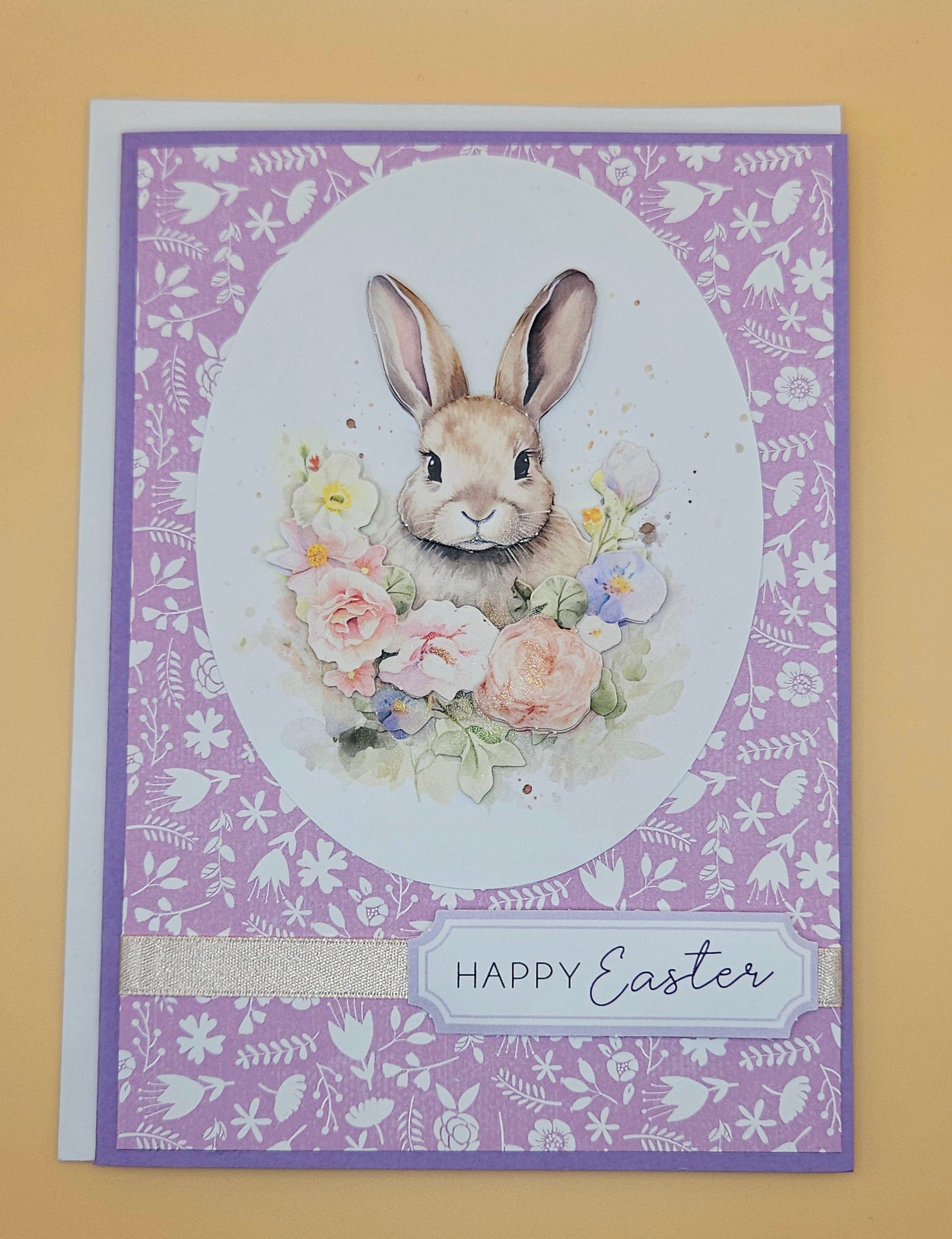 Easter card with a bunny and flowers on a purple patterned background