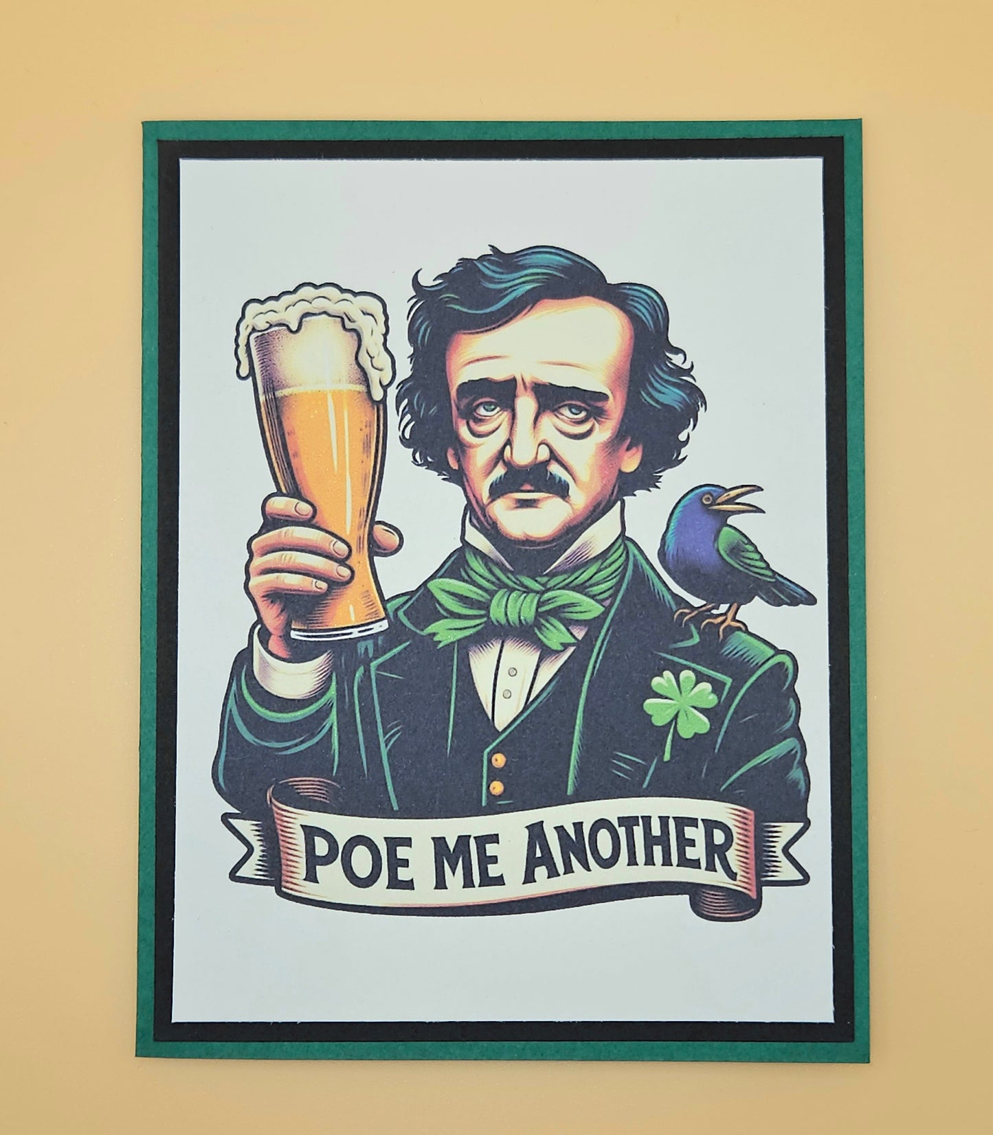 Handmade funny gothic card featuring an illustration of Edgar Allan Poe raising a frothy pint of beer with a raven on his shoulder and a small shamrock on his lapel, framed by a bold green cardstock border.