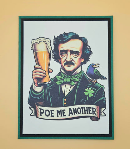 Handmade funny gothic card featuring an illustration of Edgar Allan Poe raising a frothy pint of beer with a raven on his shoulder and a small shamrock on his lapel, framed by a bold green cardstock border.