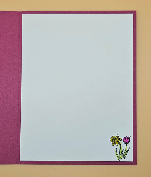 White card with a purple border featuring a small illustration of flowers on a beige background