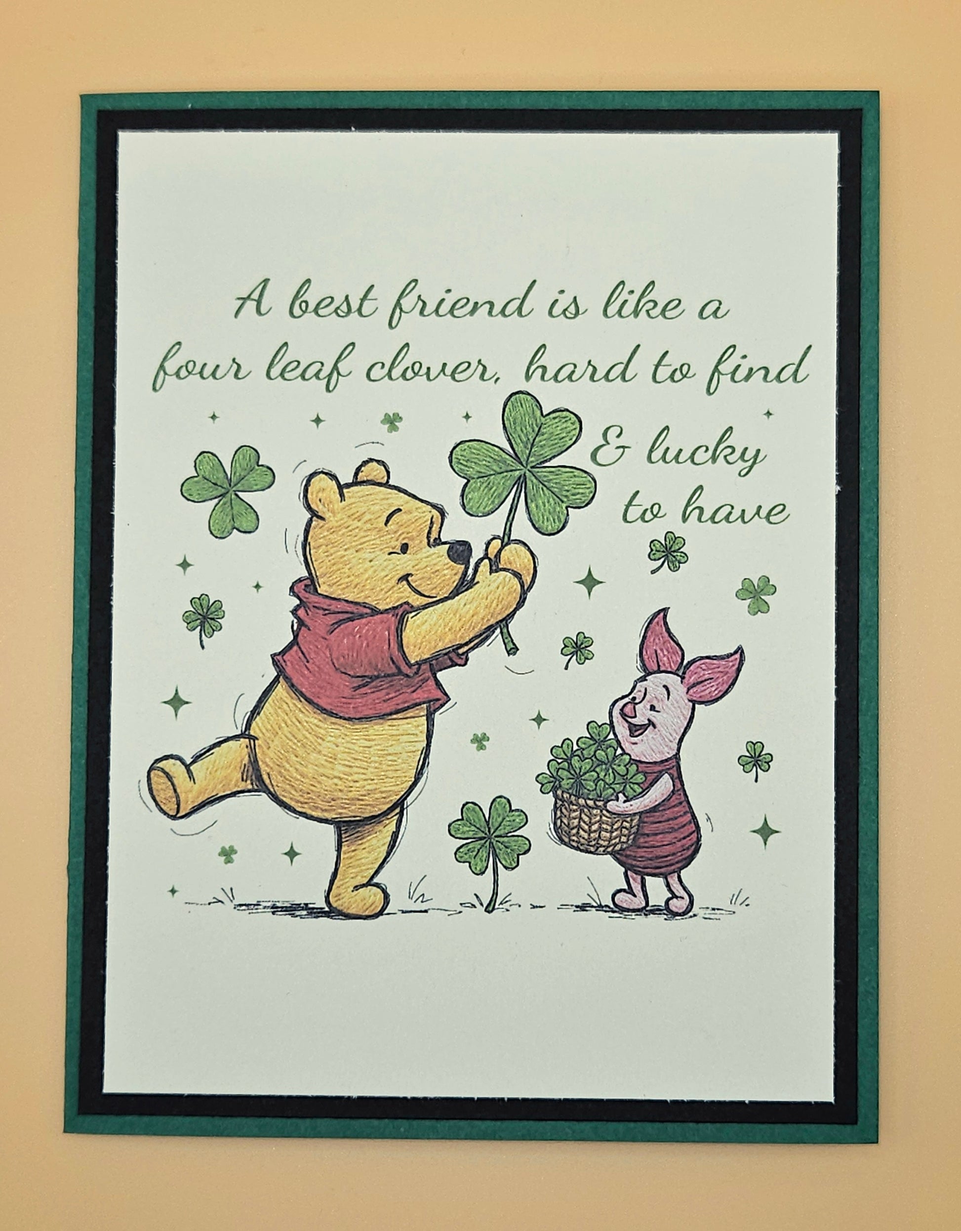 Framed print with Winnie the Pooh and Piglet holding four-leaf clovers and text on a beige background.