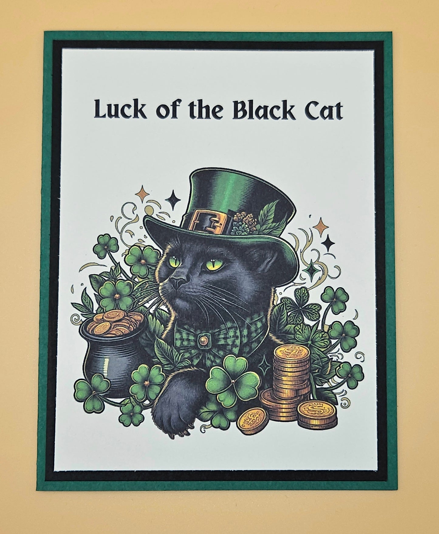 Framed artwork of a black cat wearing a green top hat with 'Luck of the Black Cat' text.