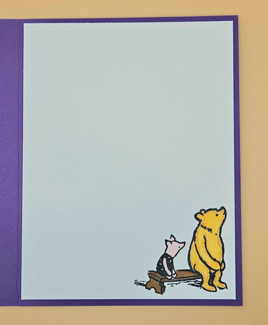 Cartoon bear and mouse sitting on a bench with a purple border