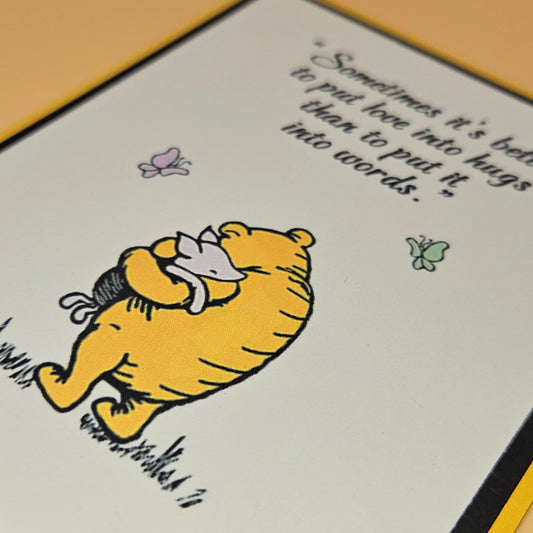 Illustration of a bear hugging a mouse with a quote on a card.