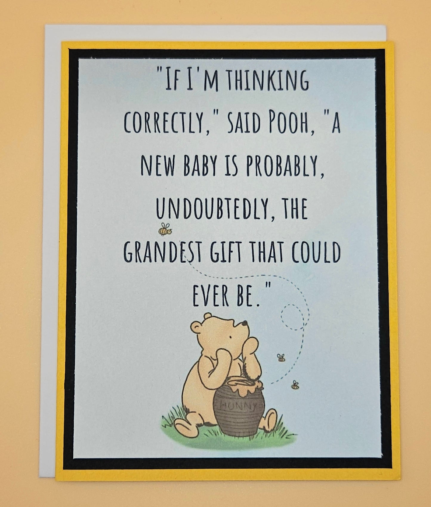 Card with Winnie the Pooh and a quote about a new baby on a beige background