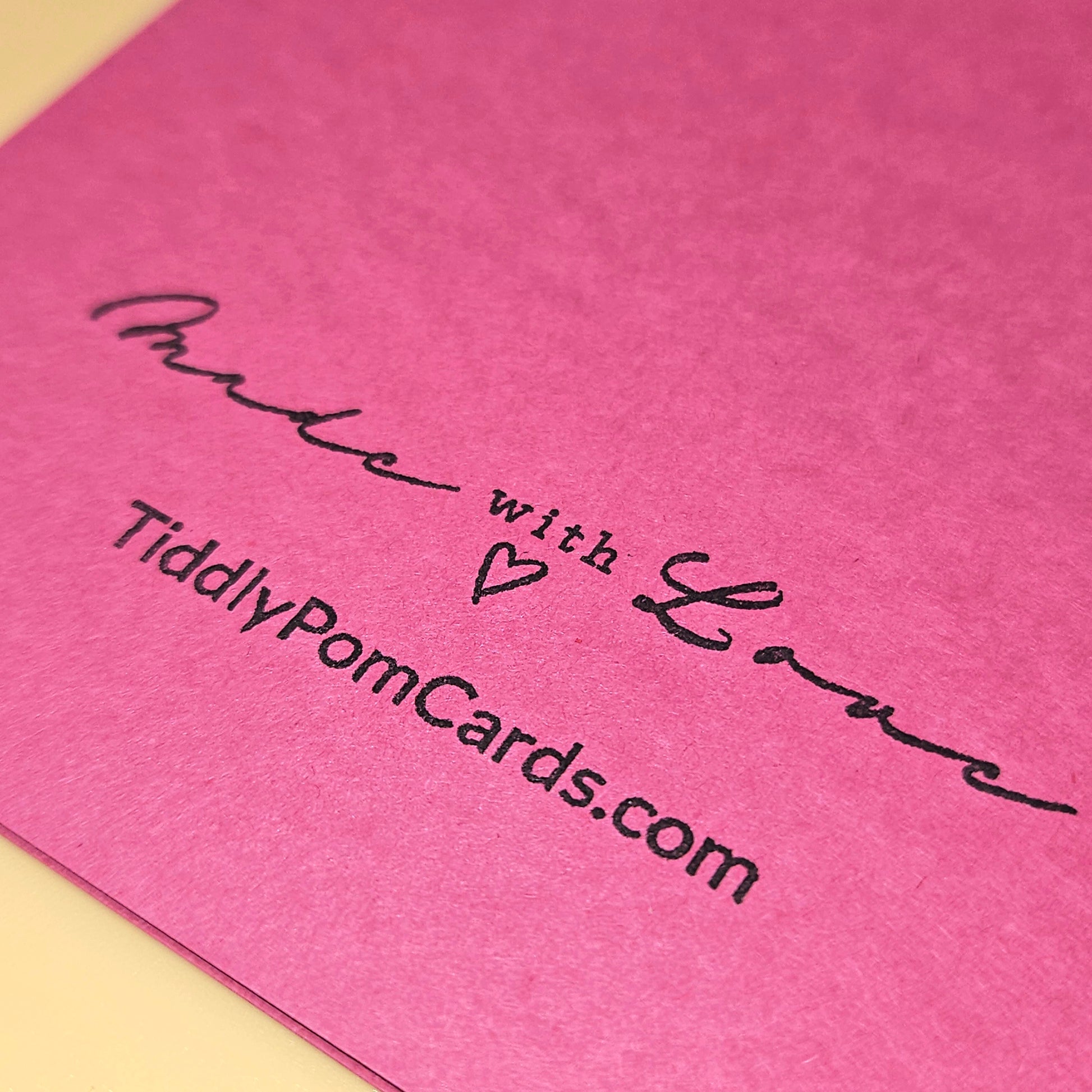 Pink card with 'Made with Love' and website text on a pink background