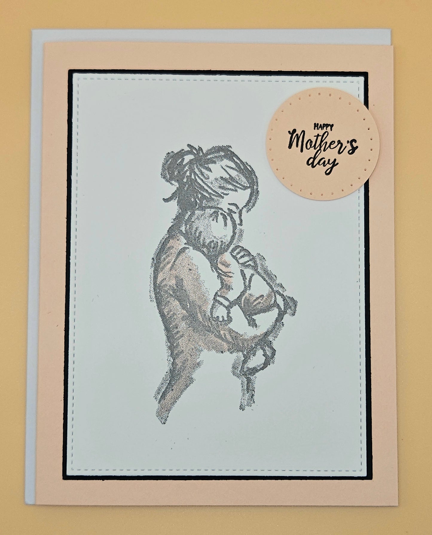 Card with a mother and child illustration and 'Happy Mother's Day' tag on a beige background