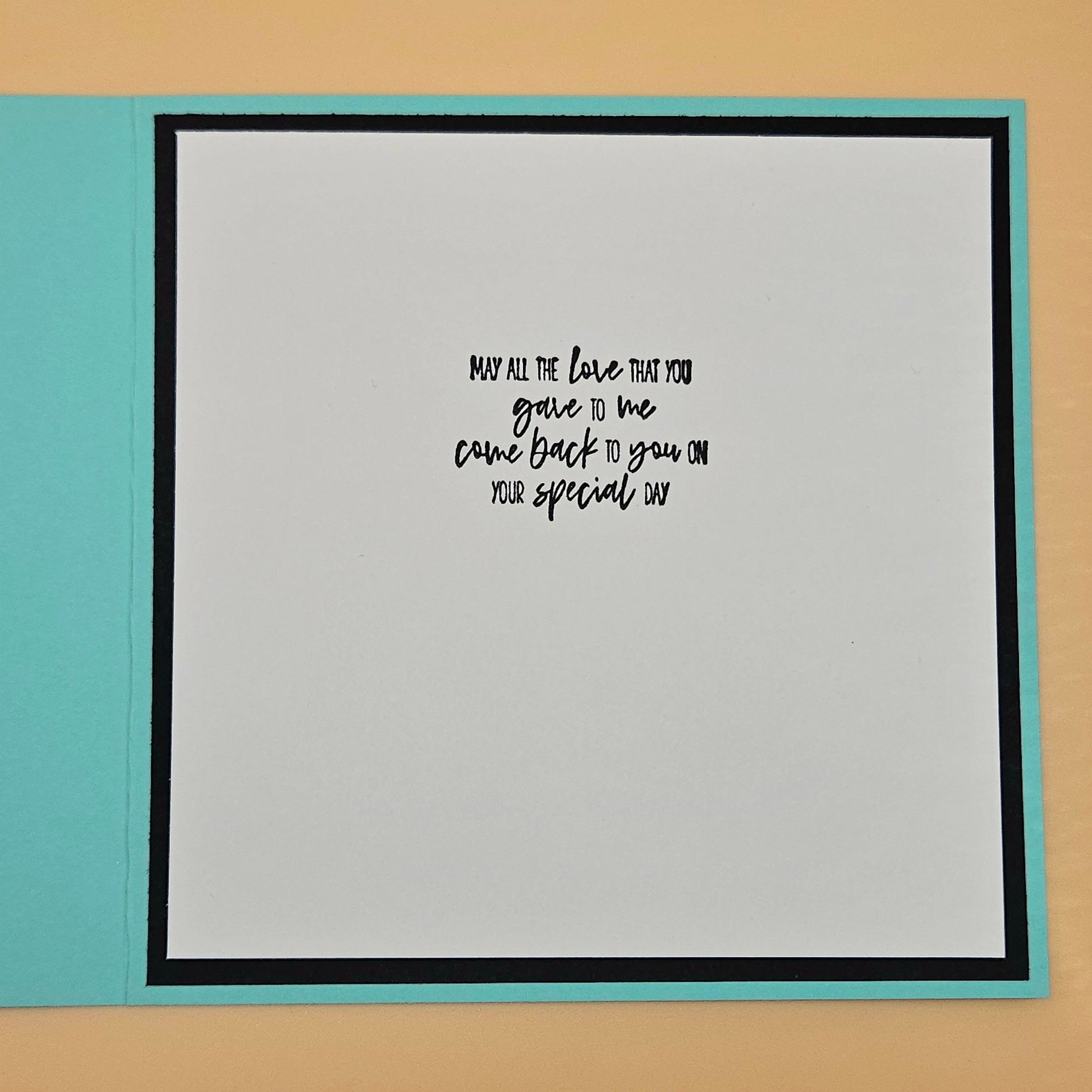 Card with a message on a light gray background with a black border, placed on a beige surface.