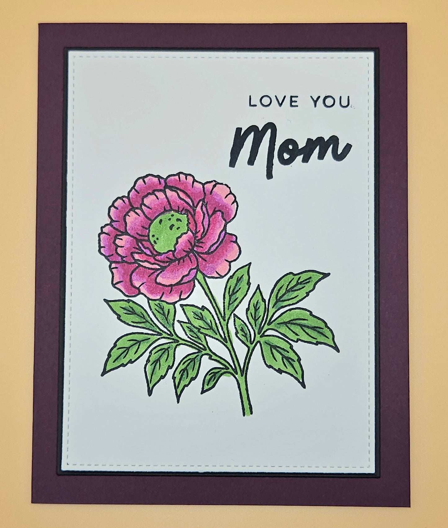Card with a pink flower illustration and 'Love You Mom' text on a beige background