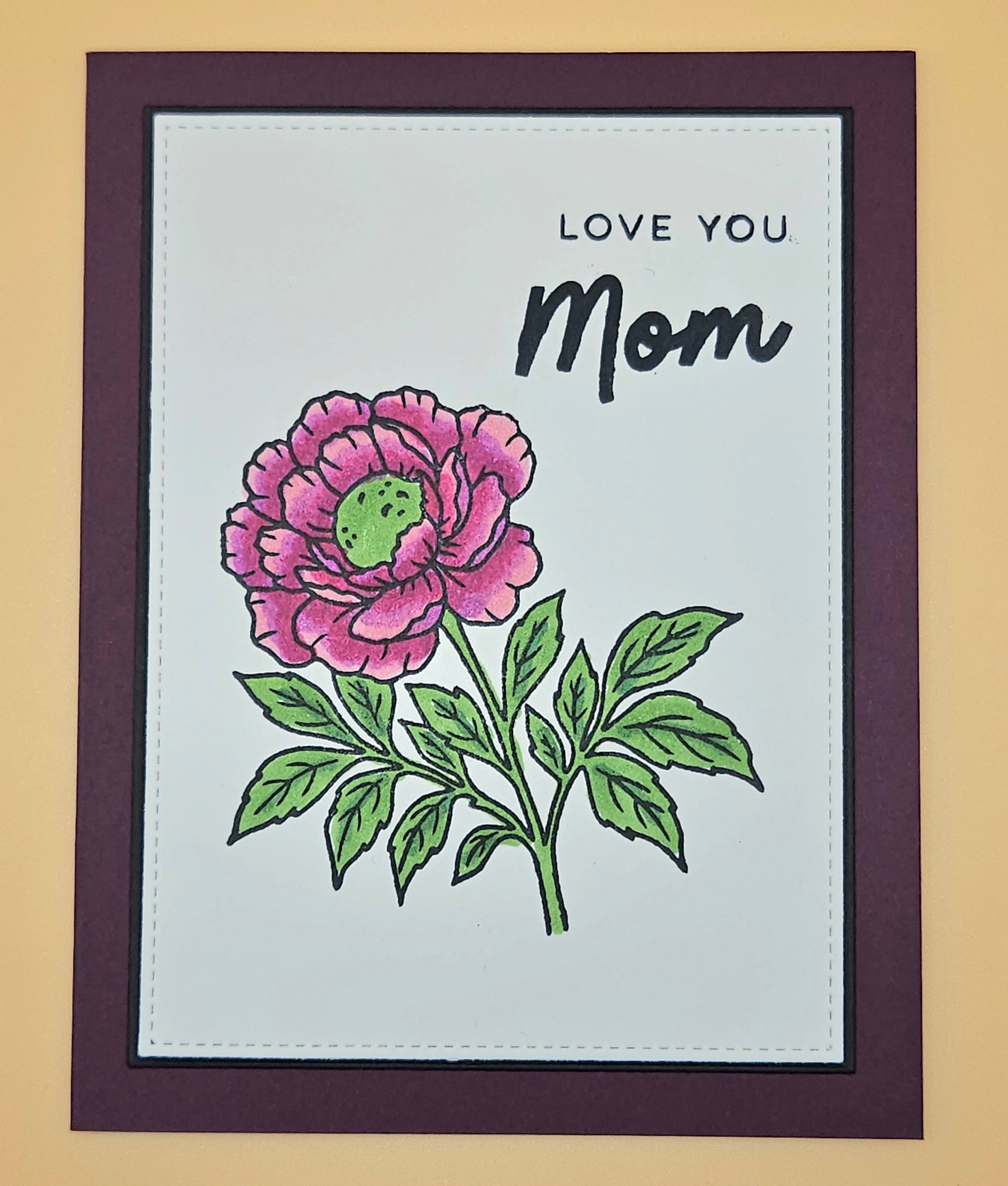 Card with a pink flower illustration and 'Love You Mom' text on a beige background